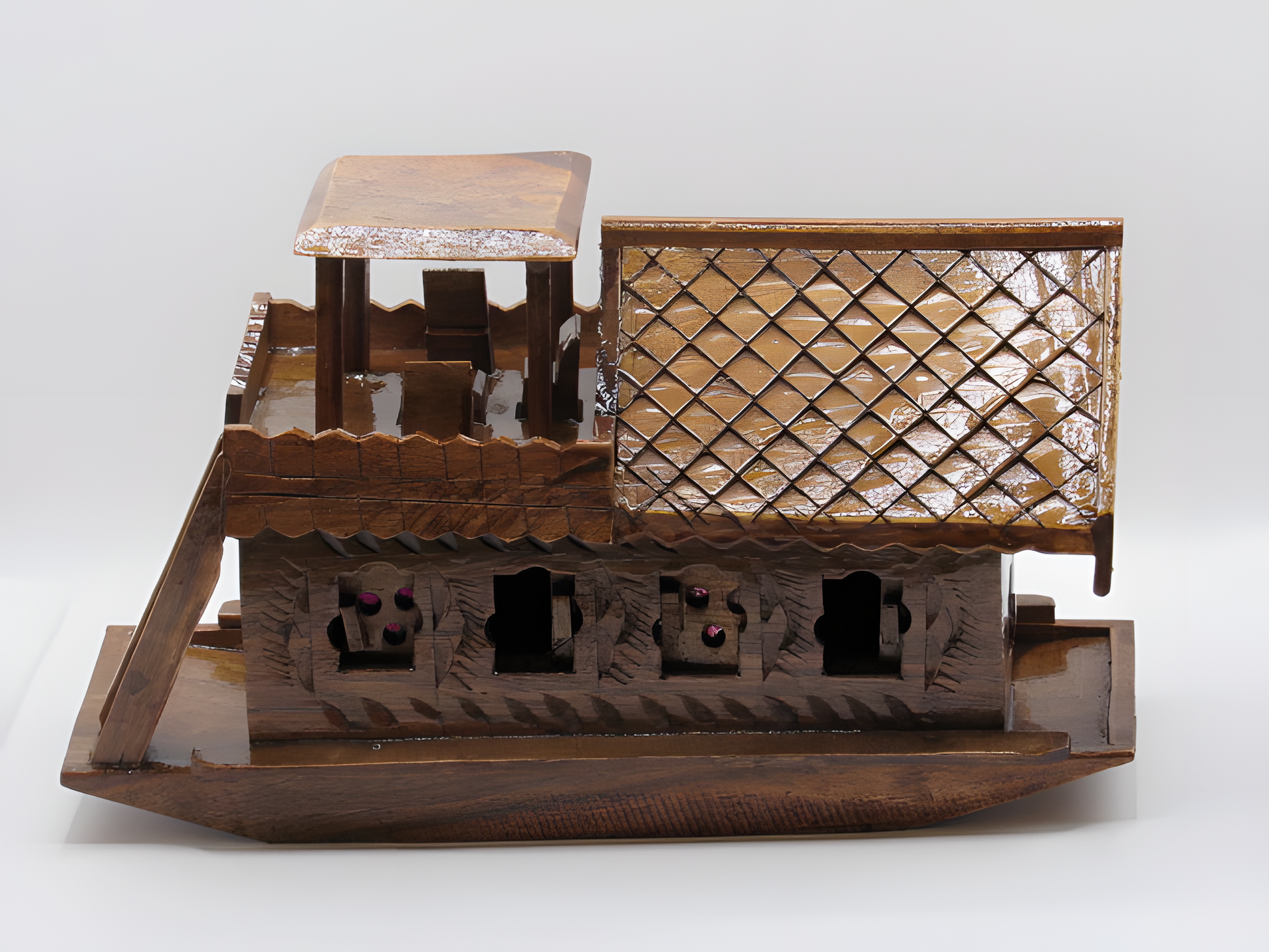 Wooden model of a traditional boat with intricate details on a white background